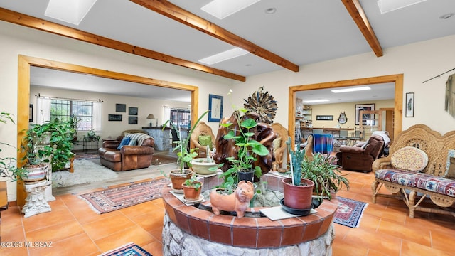 living room with tile patterned flooring, beam ceiling, and a skylight