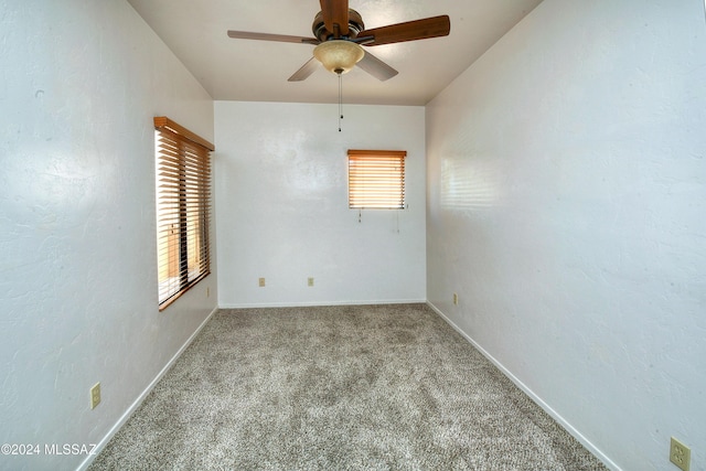 carpeted spare room featuring ceiling fan