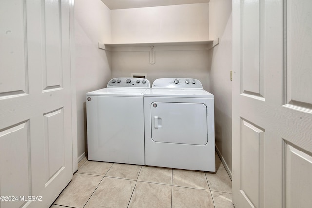 clothes washing area featuring separate washer and dryer and light tile patterned flooring