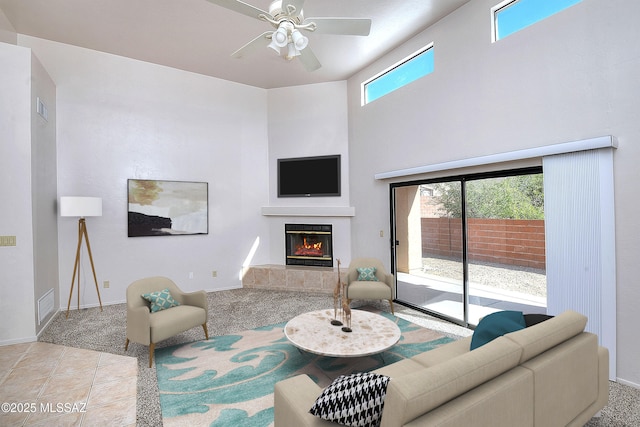 tiled living room featuring ceiling fan, a fireplace, and a wealth of natural light