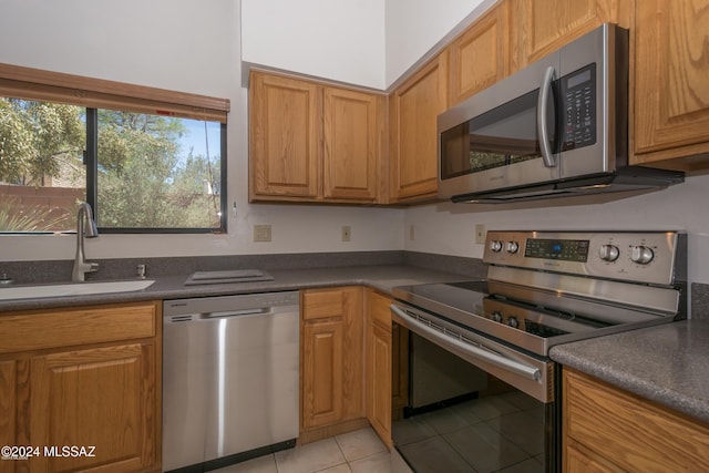 kitchen featuring appliances with stainless steel finishes, light tile patterned floors, and sink