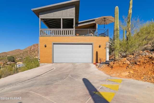 contemporary home featuring a garage, a balcony, and a mountain view