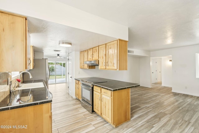 kitchen with light brown cabinets, sink, light hardwood / wood-style flooring, ceiling fan, and appliances with stainless steel finishes