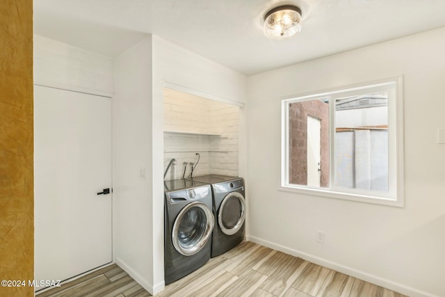 clothes washing area featuring washer and dryer and light wood-type flooring