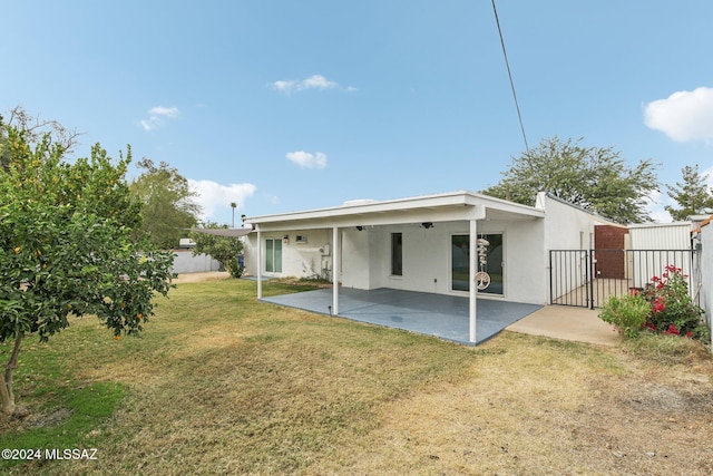 back of property with a yard and a patio