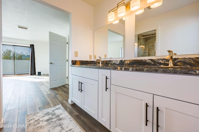 bathroom featuring wood-type flooring, vanity, and walk in shower