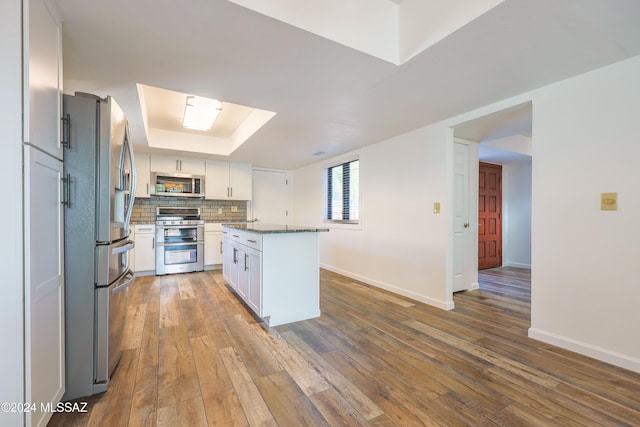 kitchen with white cabinetry, a kitchen island, hardwood / wood-style flooring, and appliances with stainless steel finishes