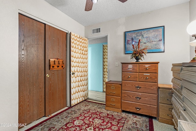 bedroom with ceiling fan, a closet, and a textured ceiling