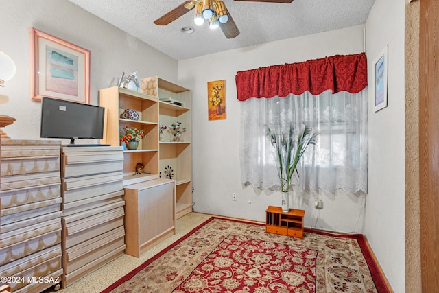 interior space with ceiling fan and a textured ceiling