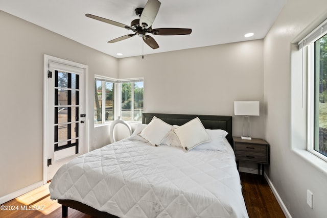 bedroom with dark wood-type flooring, ceiling fan, and multiple windows