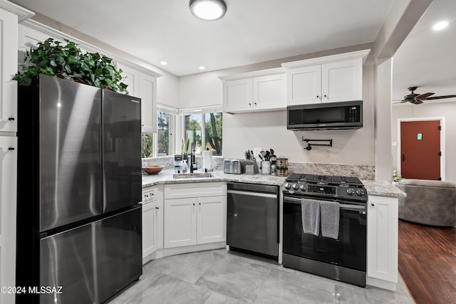 kitchen featuring white cabinetry, stainless steel appliances, sink, and light stone counters