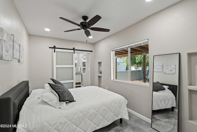 bedroom featuring a barn door and ceiling fan