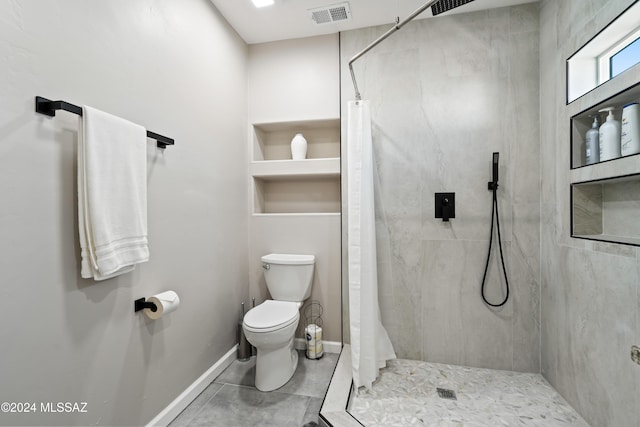 bathroom featuring tile patterned floors, toilet, and curtained shower