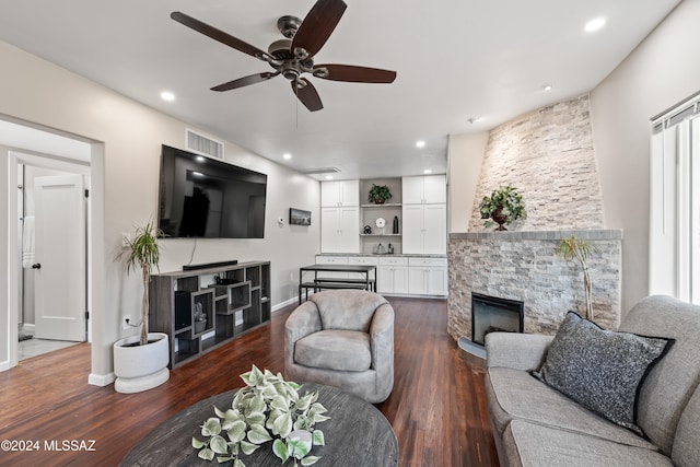 living room with ceiling fan, dark hardwood / wood-style floors, and a fireplace