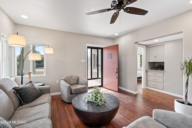 living room with ceiling fan and dark hardwood / wood-style flooring