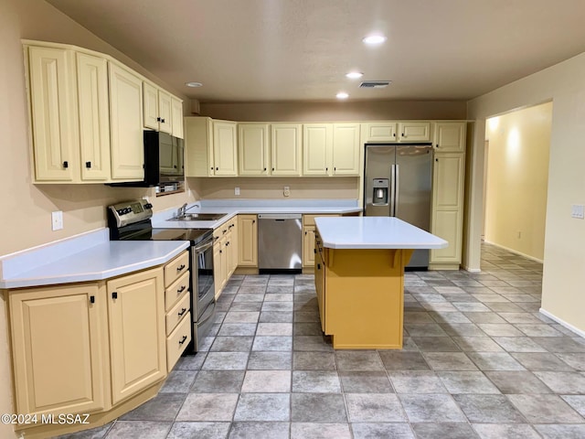 kitchen featuring sink, cream cabinetry, a kitchen island, a kitchen bar, and stainless steel appliances