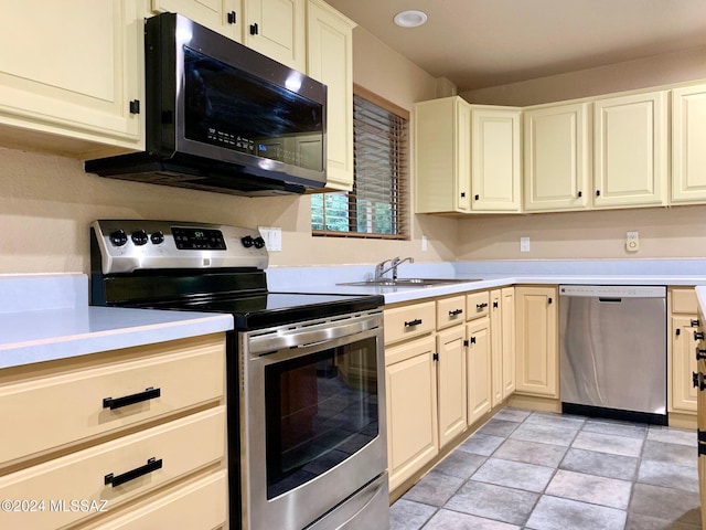 kitchen with sink, light tile patterned flooring, and stainless steel appliances