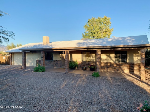 ranch-style home with a patio and a garage