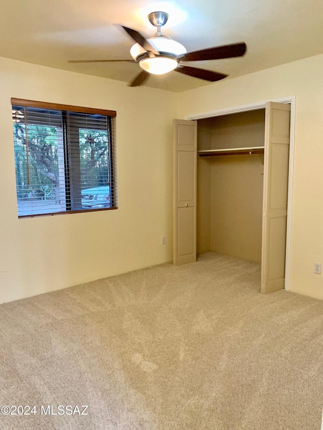 unfurnished bedroom with carpet, a closet, and ceiling fan