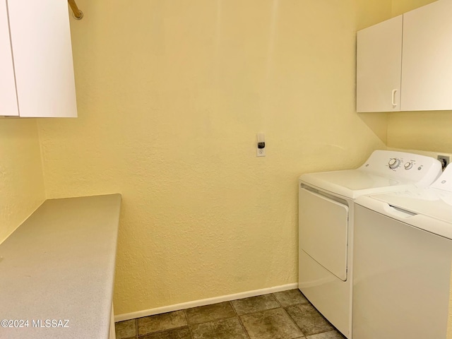 clothes washing area with washing machine and clothes dryer and cabinets