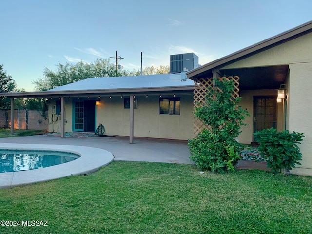 view of swimming pool with a yard, a patio, and central AC unit