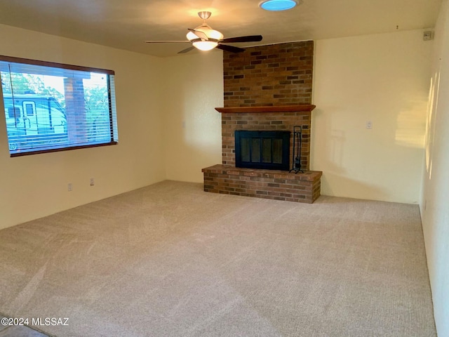 unfurnished living room featuring carpet, ceiling fan, and a fireplace