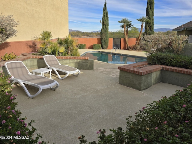 view of pool featuring a mountain view and a patio area