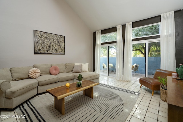 living room with light tile patterned floors and high vaulted ceiling