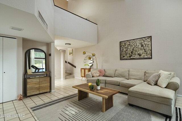 living room featuring a towering ceiling and light tile patterned floors