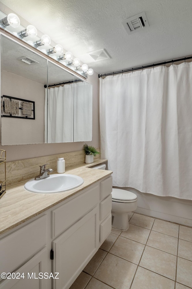 full bathroom with vanity, tile patterned flooring, toilet, a textured ceiling, and shower / tub combo