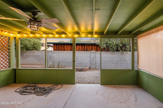 unfurnished sunroom featuring ceiling fan