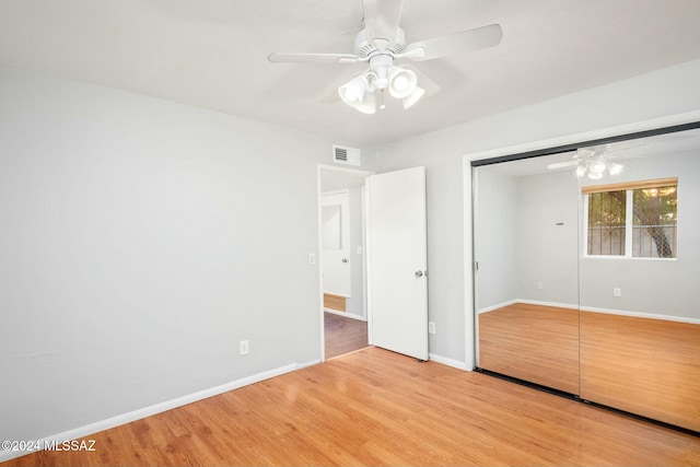 unfurnished bedroom featuring hardwood / wood-style flooring, ceiling fan, and a closet