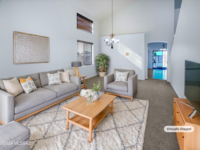 carpeted living room with high vaulted ceiling and a chandelier