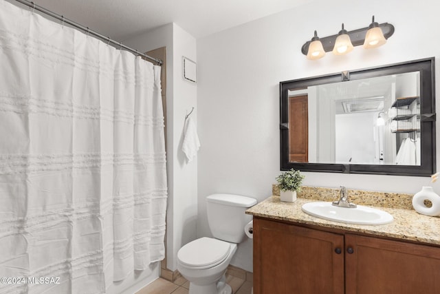 bathroom with tile patterned flooring, vanity, and toilet