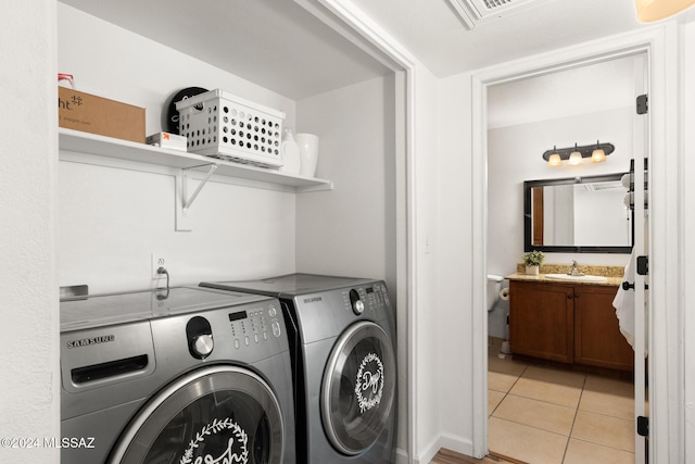 clothes washing area with light tile patterned floors, separate washer and dryer, and sink