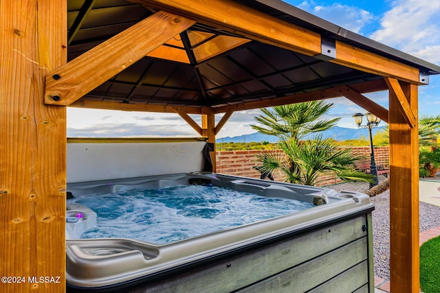 view of patio featuring a gazebo, a mountain view, and a hot tub