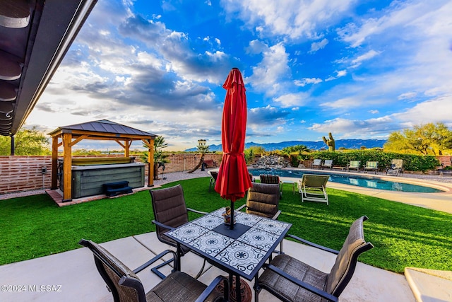 view of patio / terrace with a gazebo and a swimming pool with hot tub