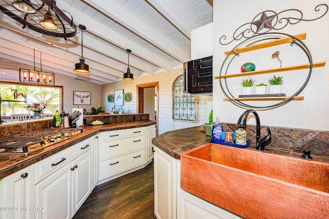 kitchen with hanging light fixtures, sink, white cabinets, and dark wood-type flooring