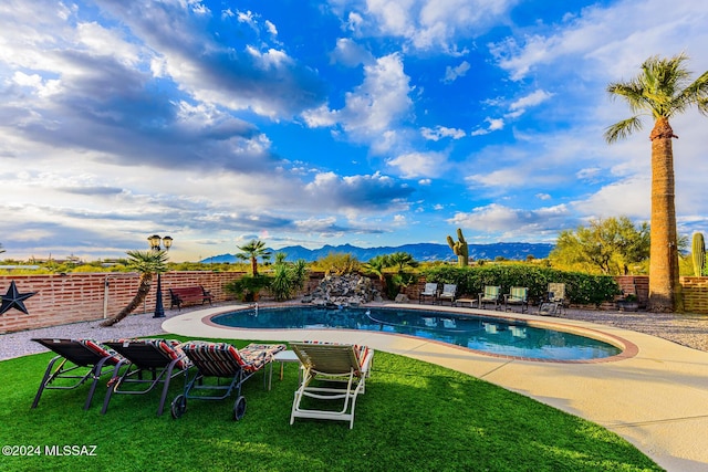 view of pool featuring a mountain view, a patio area, and a yard