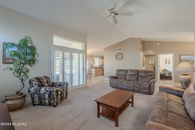 living room featuring ceiling fan, light colored carpet, and lofted ceiling