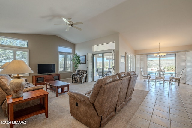 living room featuring light tile patterned floors, ceiling fan with notable chandelier, and a healthy amount of sunlight