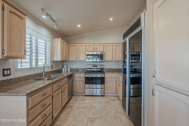 kitchen with light brown cabinets, sink, appliances with stainless steel finishes, and vaulted ceiling