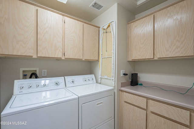 laundry area featuring cabinets, a textured ceiling, and washer and dryer