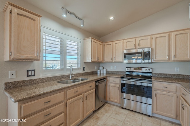 kitchen with lofted ceiling, sink, light brown cabinetry, appliances with stainless steel finishes, and light tile patterned flooring