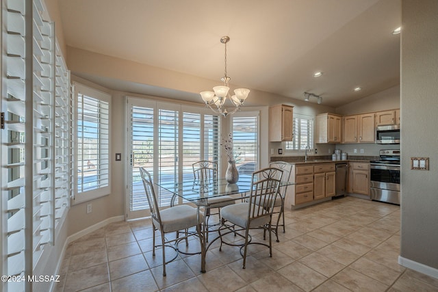 dining room with a chandelier, light tile patterned floors, and vaulted ceiling