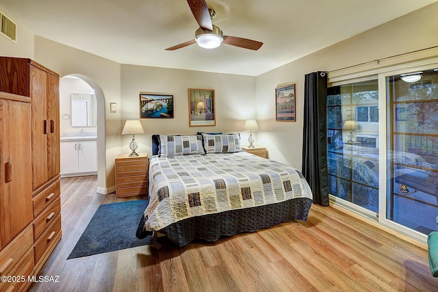 bedroom featuring ceiling fan, ensuite bathroom, and light hardwood / wood-style flooring