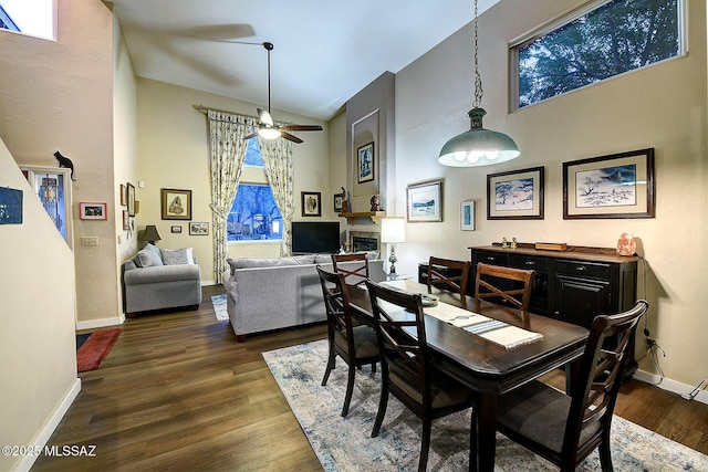 dining space featuring high vaulted ceiling, ceiling fan, and dark wood-type flooring