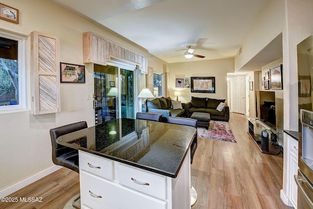 kitchen with a breakfast bar, light wood-type flooring, and a kitchen island