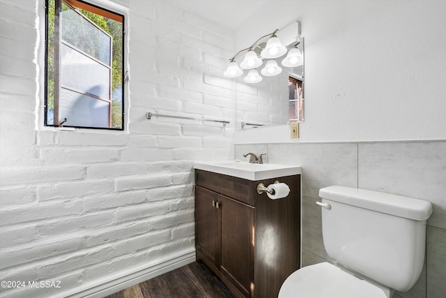 bathroom with toilet, vanity, and hardwood / wood-style flooring