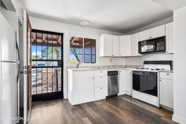 kitchen with dark wood-type flooring, sink, stainless steel fridge, white gas stove, and white cabinetry